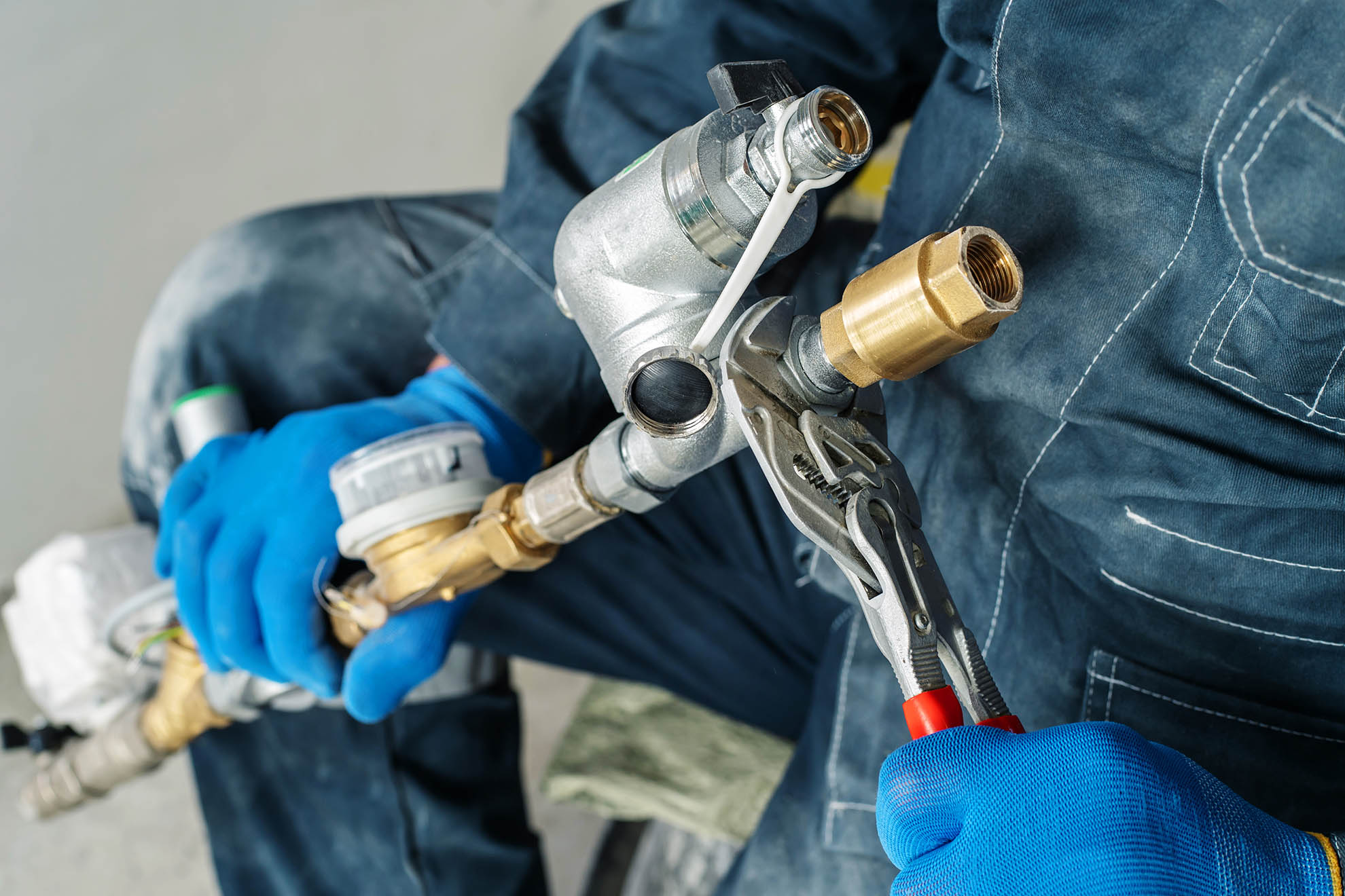 A plumber assembles a heating system using a wrench. Cropped frame. Unrecognizable person